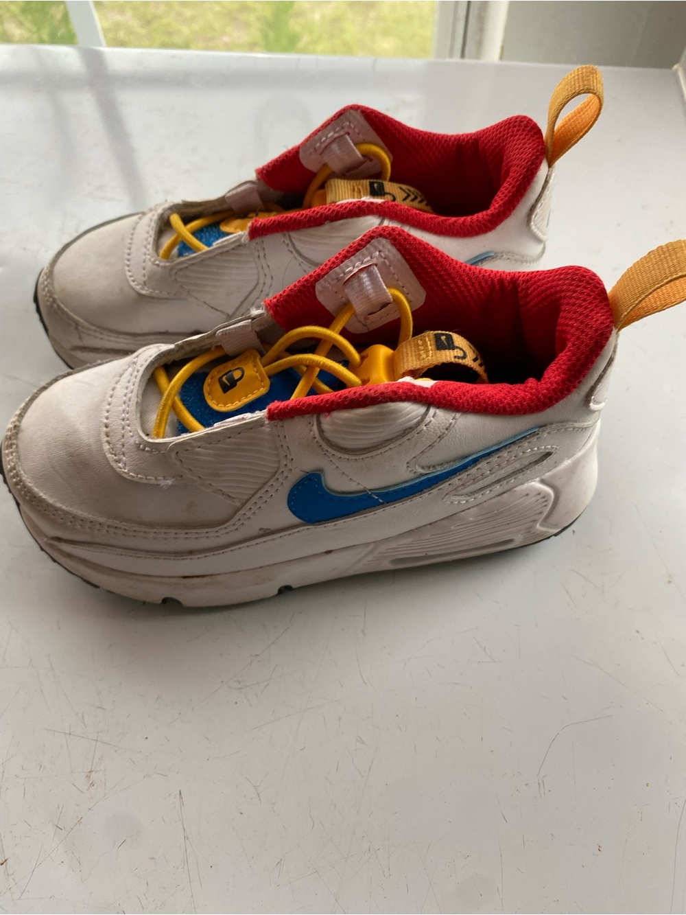 Nike Kids White Sneakers with Blue Swoosh and Red Lining, Yellow Pull Tabs